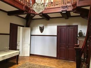 A room with a chandelier and a door

Description automatically generated